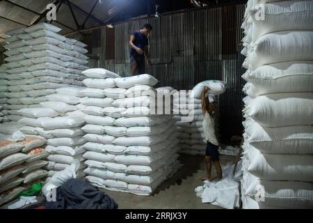 220811 -- YANGON, Aug. 11, 2022 -- Workers pile sacks of rice at a warehouse in Yangon, Myanmar on Aug. 11, 2022. Myanmar s agricultural export earnings decreased 1.25 percent to about 1.27 billion U.S. dollars year on year in the first four months of the present fiscal year FY 2022-2023, according to the Ministry of Commerce. The Southeast Asian country changed its fiscal year from the original October-September to April-March beginning this year. Photo by /Xinhua MYANMAR-YANGON-AGRICULTURAL EXPORT-DECLINE MyoxKyawxSoe PUBLICATIONxNOTxINxCHN Stock Photo