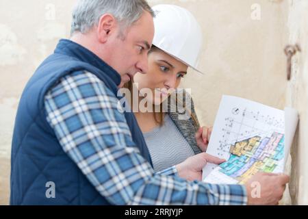 surveyors in discussion while looking at blueprints Stock Photo