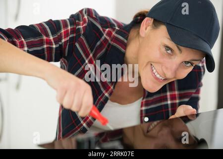 happy woman builder using a screwdriver Stock Photo