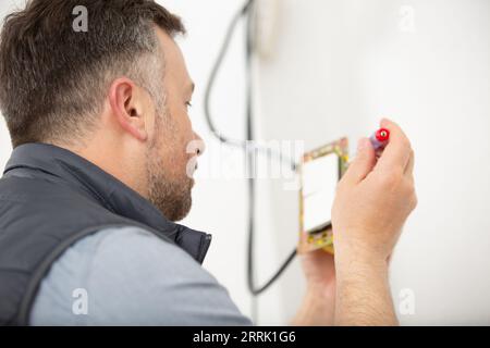 electrician at work with nippers in hand doing wiring Stock Photo