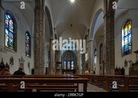 The central nave of the cathedral of San Francesco in travertine and with colored and stained glass windows. Ascoli Piceno, Marche region, Italy Stock Photo