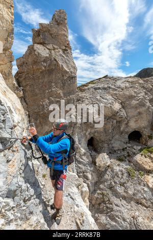 Italy, Veneto, Province of Belluno, San Nicolò di Comelico, young hiker climbs along the D'Ambros via ferrata on the Pitturina crest, Carnic Alps border between Italy and Austria Stock Photo