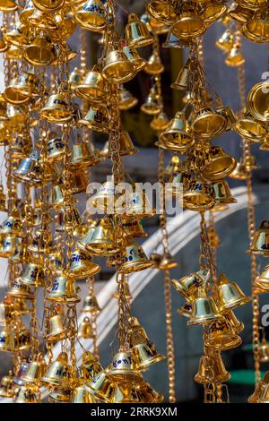 Gold colored wishing bells, Buddhist temple complex Wat Intharawihan, Bangkok, Thailand, Asia Stock Photo