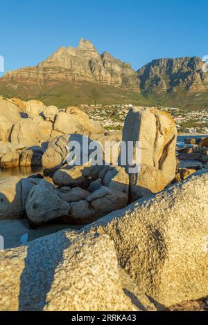 South Africa, Cape Town, Camps Bay, rocks in water, evening light, 12 Apostles mountain range Stock Photo