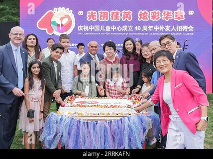 220828 -- BEIJING, Aug. 28, 2022 -- Guests and children pose for a photo at the celebration for the 40th anniversary of the founding of the China National Children s Center in Beijing, capital of China, Aug. 27, 2022. A reception for Chinese and foreign guests to celebrate the 40th anniversary of China National Children s Center was held on Saturday. Founded in 1982, China National Children s Center was the first state-level research institution for afterschool education and children s development since the reform and opening up policy was implemented in the late 1970s. Over the past 40 years, Stock Photo