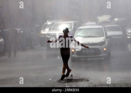 220829 -- AMMAN, Aug. 29, 2022 -- A man cools off in a spray of water from a water truck during a heatwave in Amman, Jordan, on Aug. 28, 2022. Jordan s Health Ministry on Sunday warned of high temperatures as a dry heatwave will continue to affect the country for at least two days, advising the public to avoid sunlight exposure. Photo by /Xinhua JORDAN-AMMAN-HEATWAVE MohammadxAbuxGhosh PUBLICATIONxNOTxINxCHN Stock Photo