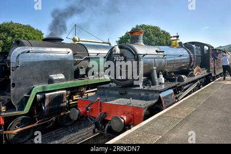 Two steam trains at the GWR preserved train station platform Winchcombe Gloucestershire England UK. No 7820 Dinmore Manor and No 35006 P7O Navy Class Stock Photo