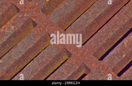 Rusted drainage grate angled view showing strong abstract diagonal line patterns and textures. Stock Photo