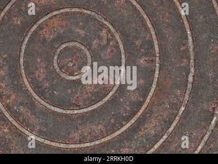 Circles pattern on an old rusted manhole cover, close up abstract image. Stock Photo