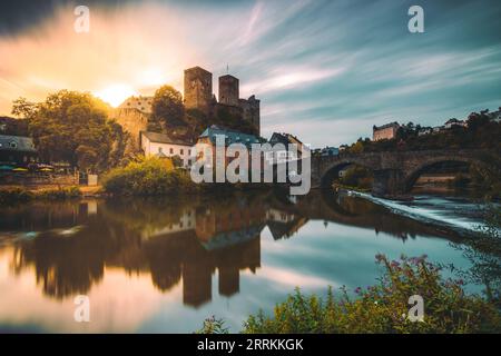 Runkel on the Lahn, beautiful old castle on the river bank reflected in the water of a weir at sunset Stock Photo