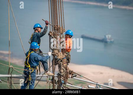 220913 -- CHONGQING, Sept. 13, 2022 -- Technicians work during the cross-Yangtze River wiring operation for the Baihetan-Zhejiang 800 kv ultra-high voltage direct current UHVDC transmission line project Chongqing section in southwest China s Chongqing, Sept. 13, 2022. After a 13-day campaign, the cross-Yangtze River wiring operation for the Baihetan-Zhejiang 800 kv ultra-high voltage direct current UHVDC transmission line project concluded successfully on Tuesday. The 2,140-kilometer line, whose construction kicked off in October 2021, winds its way through Sichuan, Chongqing, Hubei, Anhui and Stock Photo