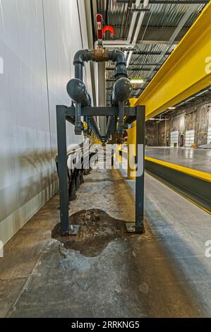 Piping for fluids to warm concrete floor in cold-storage warehouse loading dock.  Fluid is probably ethylene glycol. Stock Photo