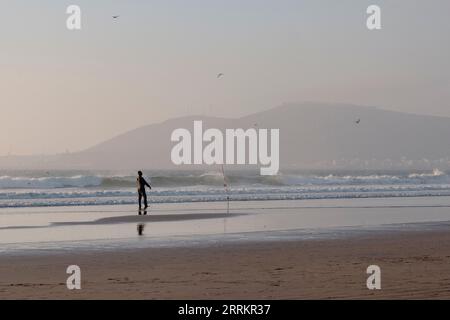 Fishing on the sandy beach by the sea Stock Photo