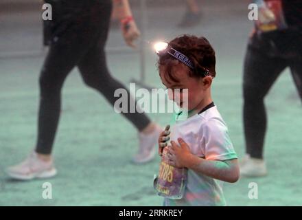 220918 -- BUCHAREST, Sept. 18, 2022 -- A boy looks at his shirt after being sprayed with colored powder during the Color Run Night fun race in Bucharest, capital of Romania, Sept. 17, 2022. Photo by /Xinhua SPROMANIA-BUCHAREST-COLOR RUN NIGHT CristianxCristel PUBLICATIONxNOTxINxCHN Stock Photo