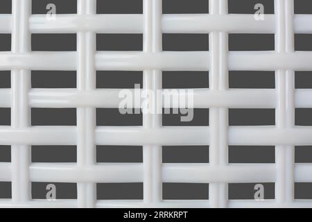 close-up of plastic grille abstract, white color geometric background texture for designing, mesh pattern structure in full frame isolated on gray Stock Photo