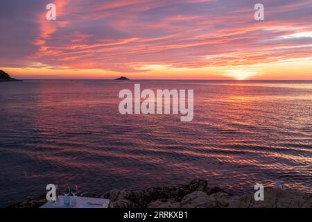 Romantic sunset  in pink and violet with a set table Stock Photo