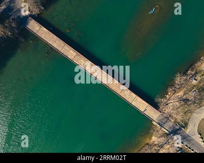 an aerial view of Mansfield Dam with crystal-clear blue water on a sunny day Stock Photo