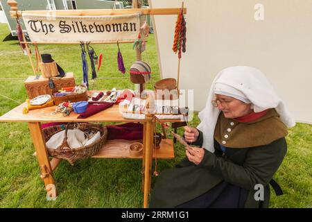 England, Kent, Maidstone, Leeds, Leeds Castle, Medieval Festival, Portrait of Woman in Medieval Costume Weaving Silk Stock Photo