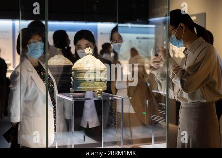 220926 -- SHANGHAI, Sept. 26, 2022 -- Visitors view an ancient bronze ware at the exhibition Return in Golden Age: China s Retrieved Cultural Relics Exhibition in east China s Shanghai, Sept. 26, 2022. Return in Golden Age: China s Retrieved Cultural Relics Exhibition was launched Monday at the Minhang Museum in east China s Shanghai. The exhibition features China s cultural relics retrieved from overseas and now kept by the Poly Art Museum and the administration office of the Yuanmingyuan. Among the exhibits are bronze Chinese zodiac animal heads that belonged to the Yuanmingyuan Park, as wel Stock Photo