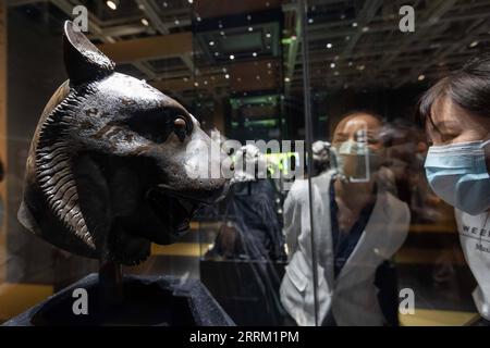 220926 -- SHANGHAI, Sept. 26, 2022 -- Visitors view a bronze tiger head at the exhibition Return in Golden Age: China s Retrieved Cultural Relics Exhibition in east China s Shanghai, Sept. 26, 2022. Return in Golden Age: China s Retrieved Cultural Relics Exhibition was launched Monday at the Minhang Museum in east China s Shanghai. The exhibition features China s cultural relics retrieved from overseas and now kept by the Poly Art Museum and the administration office of the Yuanmingyuan. Among the exhibits are bronze Chinese zodiac animal heads that belonged to the Yuanmingyuan Park, as well a Stock Photo