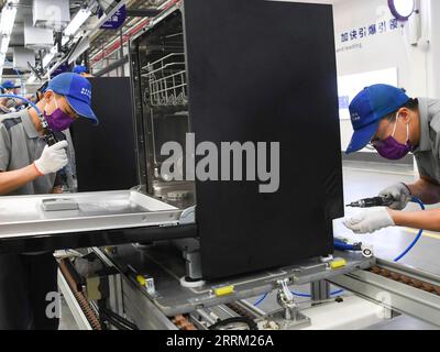 220925 -- CHONGQING, Sept. 25, 2022 -- Workers are seen at the production line of a dishwasher interconnected factory of Chongqing Haier Washing Electric Appliances Co.LTD in southwest China s Chongqing, Sept. 25, 2022. A dishwasher interconnected factory of Chongqing Haier Washing Electric Appliances Co.LTD was officially put into production here at Gangcheng Industry Park in Jiangbei District of Chongqing on Sunday. This 42,000-square-meter factory, with a designed annual output of one million dishwashers, will utilize advanced technologies like 5G and Industrial Internet towards the digitiz Stock Photo