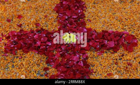 Cross made my red rose and marigold flower leaves Stock Photo