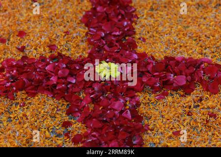 Cross made my red rose and marigold flower leaves Stock Photo