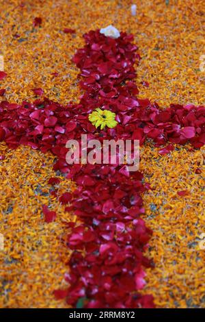 Cross made my red rose and marigold flower leaves Stock Photo