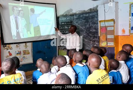 221015 -- WAKISO, Oct. 15, 2022 -- Pupils attend class about Ebola using a StarTimes projector at St. Claire Primary School in Kampala, Uganda, Oct. 13, 2022. The Access to Satellite TV for 10,000 African Villages project in Uganda is implemented by Chinese satellite television, StarTimes. This project is one of the fruits of the resolutions of the Forum on China-Africa Cooperation Johannesburg Summit held in 2015 in South Africa. TO GO WITH Feature: China-aided satellite TV connects remote Ugandan villages to outside world Photo by Hajarah Nalwadda/Xinhua UGANDA-SATELLITE TV-STARTIMES JixLi P Stock Photo