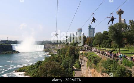 Tourists enjoying zipline ride at Niagara Falls in summer Stock Photo