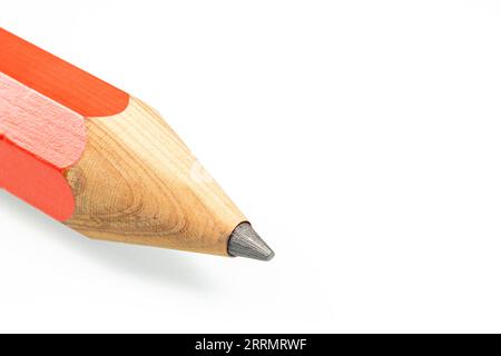 The tip of a sharpened red pencil close-up on a white background. Stock Photo