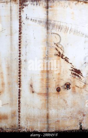 Rusty nuts on a scraped and scarred metal storage tank panel. Copy or text space Stock Photo
