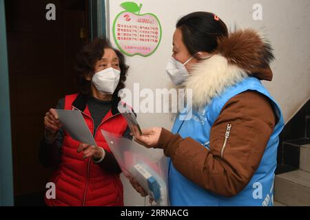 221227 -- BEIJING, Dec. 27, 2022 -- A community worker R talks with a resident in a community in Yangfangdian Subdistrict of Haidian District in Beijing, capital of China, Dec. 27, 2022. In Yangfangdian Subdistrict, care packages including medicines and COVID-19 prevention materials have been offered for senior residents living alone and those with disabilities. Shared medical kits have also been provided for residents in case of emergency.  CHINA-BEIJING-COVID-19 PREVENTION-CARE PACKAGES CN RenxChao PUBLICATIONxNOTxINxCHN Stock Photo