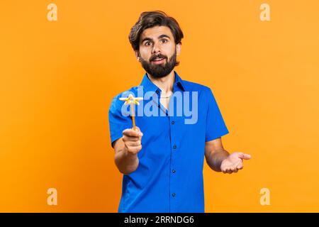 Magician witch middle eastern man gesturing with magic wand fairy stick, making wish come true, casting magician spell, advertising holidays sale discount. Guy isolated on orange studio background Stock Photo