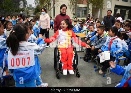 230110 -- BEIJING, Jan. 10, 2023 -- Xia Jiangbo C interacts with students during the school sports day in a primary school in Shiquan County, northwest China s Shaanxi Province, Nov. 3, 2022. Xia is a deputy to the 20th National Congress of the Communist Party of China CPC and a trainer of a sports administration center in Shiquan County. Xia won two gold medals at the London 2012 Summer Paralympics. She has claimed 35 gold medals and broken the world record four times.  XINHUA-PICTURES OF THE YEAR 2022-CHINA NEWS ShaoxRui PUBLICATIONxNOTxINxCHN Stock Photo