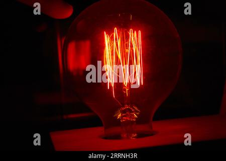 A photo of a red lightbulb in the dark. Stock Photo