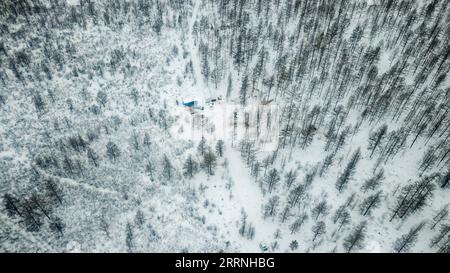 230113 -- GENHE, Jan. 13, 2023 -- This aerial photo taken on Jan. 12, 2023 shows a temporary herding station deep in the Jinhe forest range near Genhe City, north China s Inner Mongolia Autonomous Region, Jan. 12, 2023. Every two or three days, Juele Bulituotian will head for the Jinhe forest range about 80 kilometers from Genhe City. That s where the 39-year-old Aoluguya Ewenki herder, wearing a traditional fur coat, will find his foraging reindeer. Instead of keeping reindeer in a barn, Ewenki herders let the animals live in the forest and check on them every couple of days. Juele owns over Stock Photo