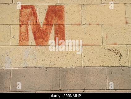 Old worn letter M, showing its age, pattern, lines and boldly grabbing attention.  Be noticed with this single letter, Stock Photo