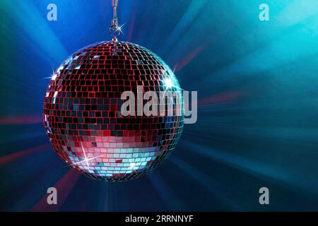 Shiny disco ball under blue lights, space for text Stock Photo