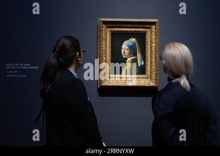 230207 -- AMSTERDAM, Feb. 7, 2023 -- Visitors view the artwork Girl with a Pearl Earring by Dutch painter Johannes Vermeer during a press preview of an exhibition at Rijksmuseum in Amsterdam, the Netherlands, on Feb. 7, 2023. With loans from all over the world, the exhibition is expected to be the largest Vermeer exhibition ever and is scheduled to open to the public from Feb. 10 to June 4. Photo by /Xinhua THE NETHERLANDS-AMSTERDAM-VERMEER-EXHIBITION SylviaxLederer PUBLICATIONxNOTxINxCHN Stock Photo