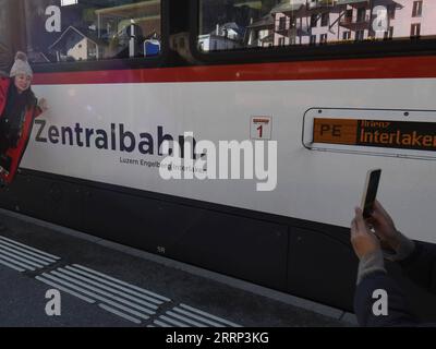 230215 -- GENEVA, Feb. 15, 2023 -- A Chinese tourist poses for a photo with the Zentralbahn from Lucerne to Interlaken during a break in Switzerland, Feb. 14, 2023. A group of 25 people from China visited the city of Lucerne and the popular scenic spot and winter sports resort Jungfrau in central Switzerland on Feb. 13-14, after three years of pandemic-related hiatus. I am very excited to see all these again, said Cui Chenghai, a tourist who frequented Switzerland before the outbreak of the pandemic. It has been three years and everything here has no change, but my feeling is different. Starti Stock Photo