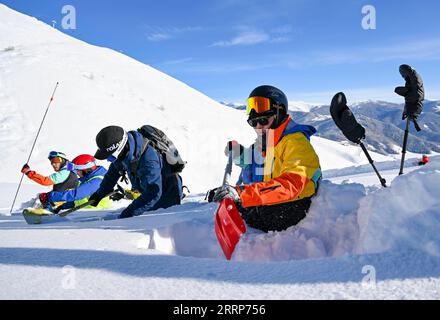 230226 -- URUMQI, Feb. 26, 2023 -- Peng Chao 1st R analyzes the characteristics of snow layers with other skiers at a ski resort in Altay, northwest China s Xinjiang Uygur Autonomous Region on Jan. 13, 2023. With its high-quality snow conditions, Xinjiang in northwest China has built a number of high-standard ski resorts and become a new hotspot for winter sports. The snow season in Altay, which is located in the northernmost part of Xinjiang, can last up to seven months, making it a heaven for winter sports lovers. At the beginning of the snow season in 2021, Beijing-based skier Peng Chao ren Stock Photo