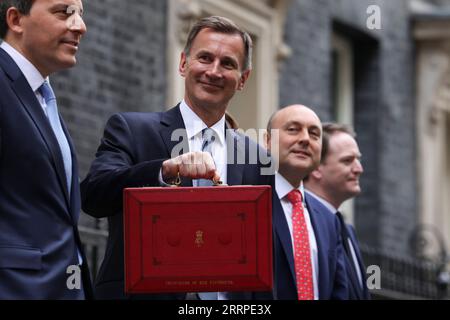 230316 -- LONDON, March 16, 2023 -- Chancellor of the Exchequer Jeremy Hunt 2nd, L of the United Kingdom UK poses for photographs as he leaves 11 Downing Street to deliver his budget to Parliament, in London, Britain, on March 15, 2023. UK on Wednesday unveiled a clutch of measures to boost its struggling economy, including childcare reforms, tax cuts for businesses, and policies to ease the cost-of-living burden for households. /No. 10 Downing Street/Handout via Xinhua BRITAIN-LONDON-JEREMY HUNT-BUDGET RoryxArnold PUBLICATIONxNOTxINxCHN Stock Photo