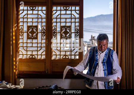 230317 -- JIANCHUAN, March 17, 2023 -- Duan Sixing checks on woodcarving patterns at his studio in Jianchuan County, Dali Bai Autonomous Prefecture of southwest China s Yunnan Province, Dec. 2, 2022. Jianchuan County, located in Dali Bai Autonomous Prefecture of southwest China s Yunnan Province, has a long history in woodcarving dating back to the Tang 618-907 and Song 960-1279 dynasties. The carving skills gradually developed from one-layer relief to even seven-layer hollowing relief, and are now applied to making architecture parts, wooden furniture, wall paintings and tourism souvenirs. A Stock Photo