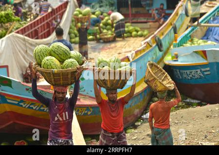 230322 -- DHAKA, March 22, 2023 -- Workers unload watermelons from a boat near a wholesale market in Dhaka, Bangladesh, March 21, 2023. BANGLADESH-DHAKA-WATERMELON TRADE Salim PUBLICATIONxNOTxINxCHN Stock Photo