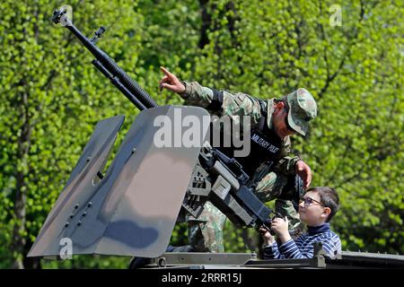 230424 -- BUCHAREST, April 24, 2023 -- A Romanian soldier talks to a child on an armoured vehicle at a static exhibition of military equipment marking Romanian Land Forces Day at a park in Bucharest, capital of Romania, April 23, 2023. Photo by /Xinhua ROMANIA-BUCHAREST-LAND FORCES DAY-EXHIBITION CristianxCristel PUBLICATIONxNOTxINxCHN Stock Photo