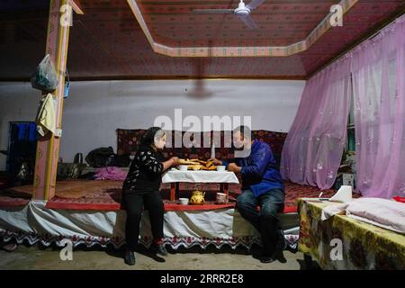 230427 -- YULI, April 27, 2023 -- Arkin Reyim has dinner with his wife in the Bax Mali Village of Yuli County, northwest China s Xinjiang Uygur Autonomous Region, April 21, 2023. Arkin Reyim is a 51-year-old cotton farmer with more than 300 mu 20 hectares of cotton fields in the Bax Mali Village of Yuli County in Xinjiang. Arkin s courage and unique vision has prompted him to start growing cotton in 2004 when he got married with his wife Hasiyat Kasim. Since then, Arkin has devoted himself into the cultivation of cotton for over 10 years, thus making him an experienced cotton grower in the cou Stock Photo