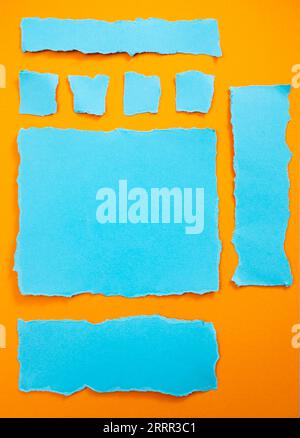 Ripped blue paper strips on orange  background, arranged as webpage elements Stock Photo