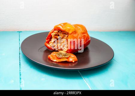 Red pepper stuffed with rice and minced meat on a black plate, romanian traditional recipe, close up Stock Photo