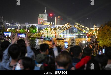 230502 -- TIANJIN, May 2, 2023 -- People take photos of the opened Jiefang Bridge in Tianjin, north China, May 1, 2023. The landmark bridge opened on Monday at a maximum angle of 60 degrees.  CHINA-TIANJIN-JIEFANG BRIDGE-NIGHT SCENERY CN SunxFanyue PUBLICATIONxNOTxINxCHN Stock Photo